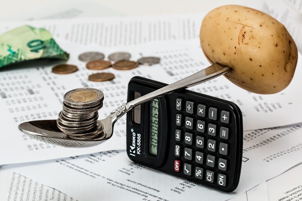 Coins, calculator, and a potato for budgeting