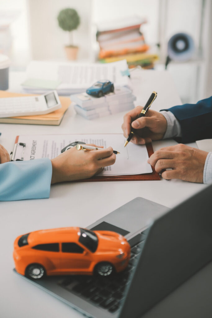 Insurance officers hand over car keys to a tenant after signing the car insurance agreement.