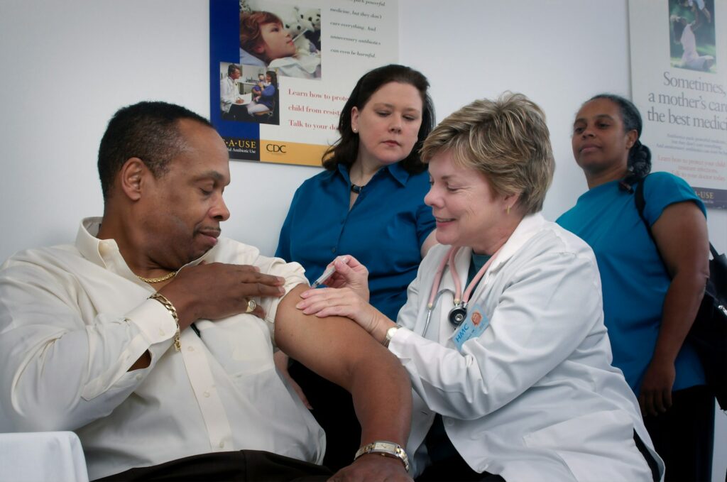 Doctor giving vaccine shot on a man