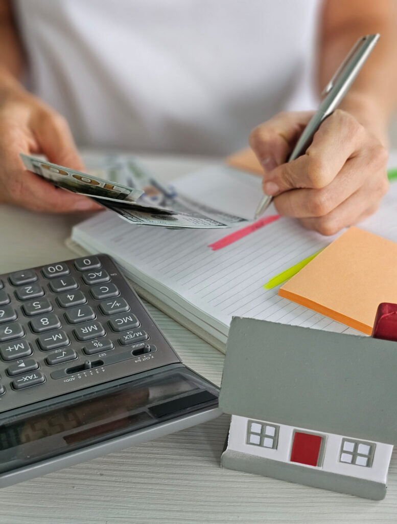 Work desk featuring a calculator and financial notes, representing the process of budgeting for a home purchase