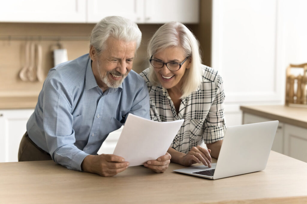 Joyful senior couple examining a legal document, both showing satisfaction and confidence in their discussion.