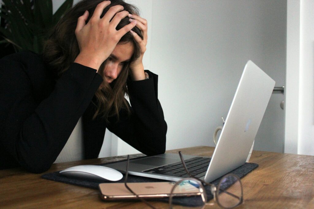 Woman stressed while looking on a laptop