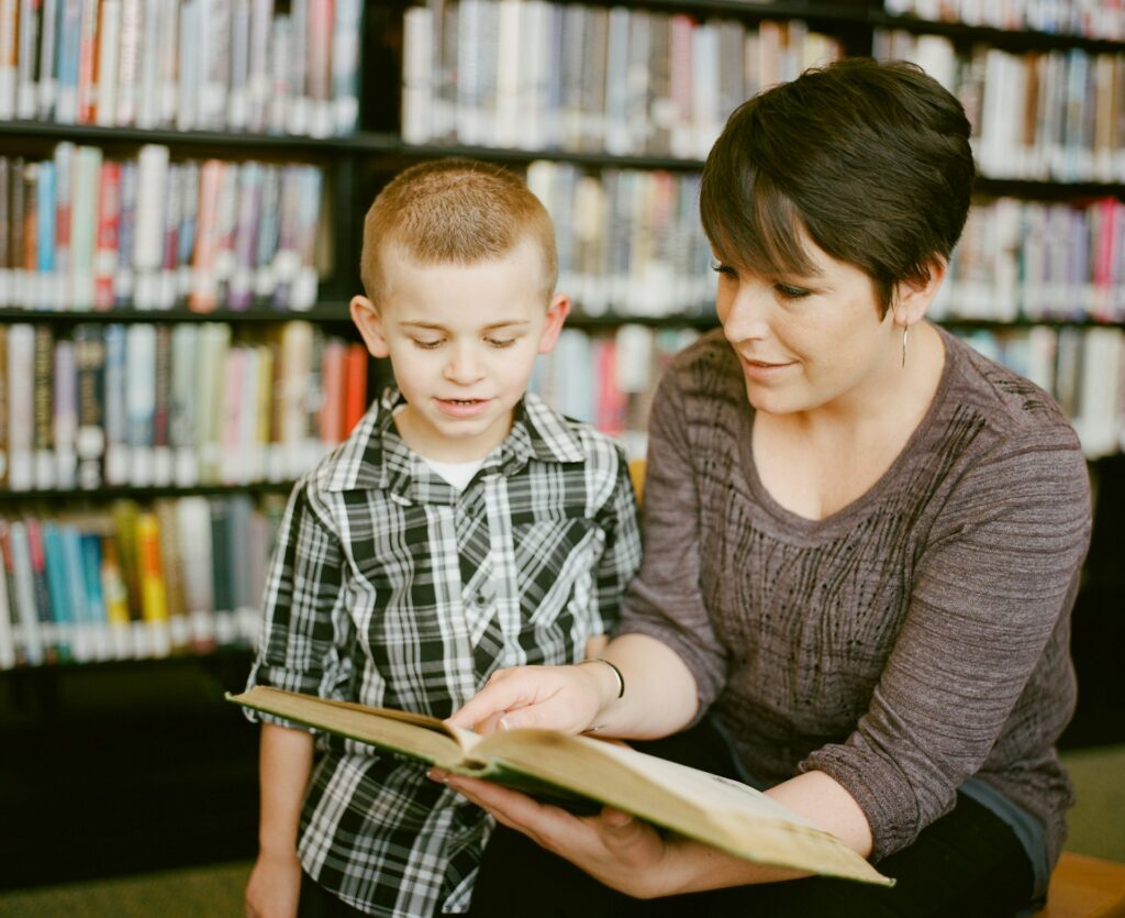 Woman teaching a kid with a book